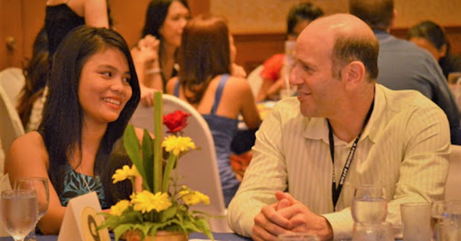 A Filipina woman talking to a Western man